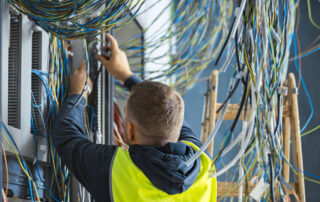 Elektrotechniker arbeitet an vielen bunten Kabeln