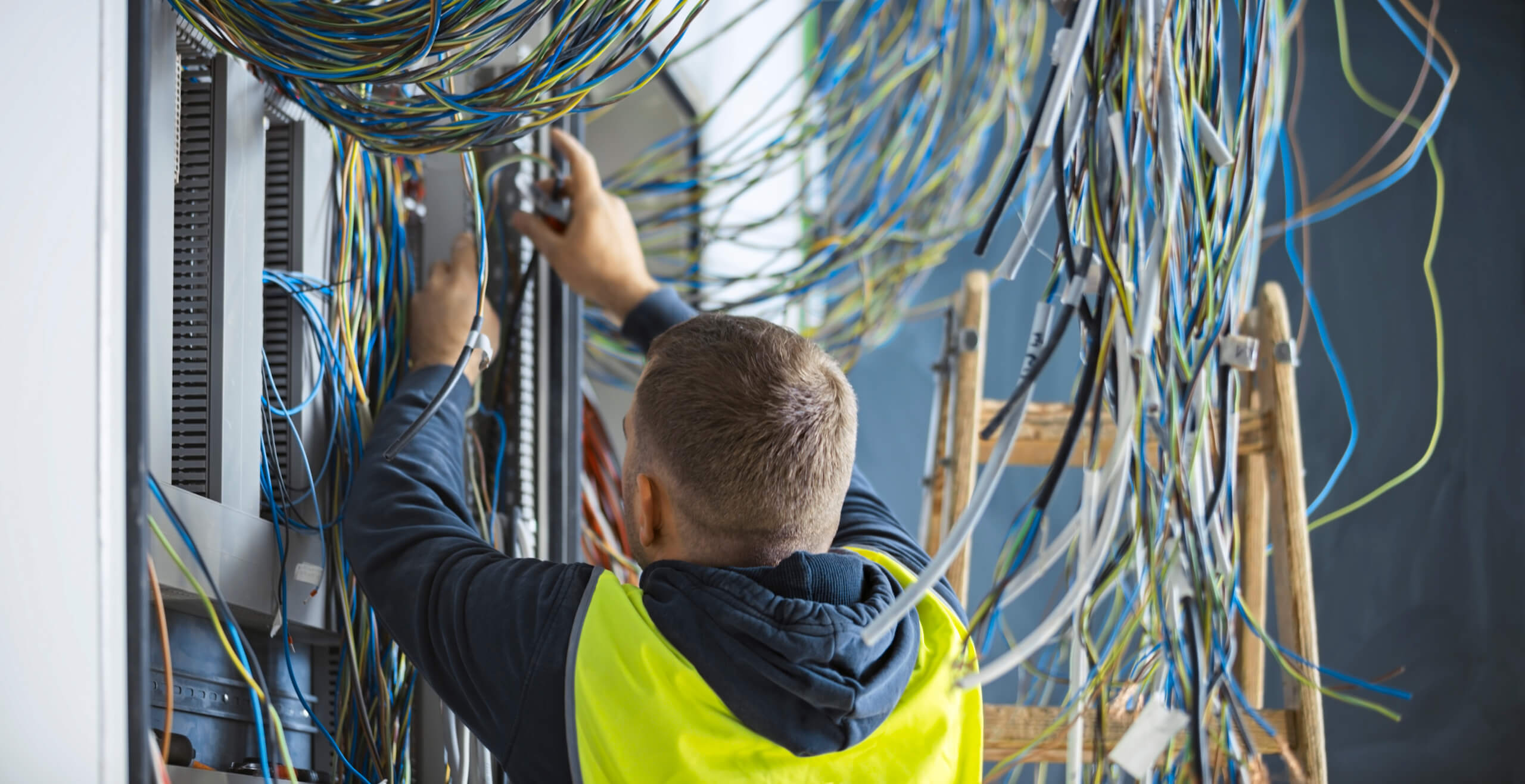 Elektrotechniker arbeitet an vielen bunten Kabeln