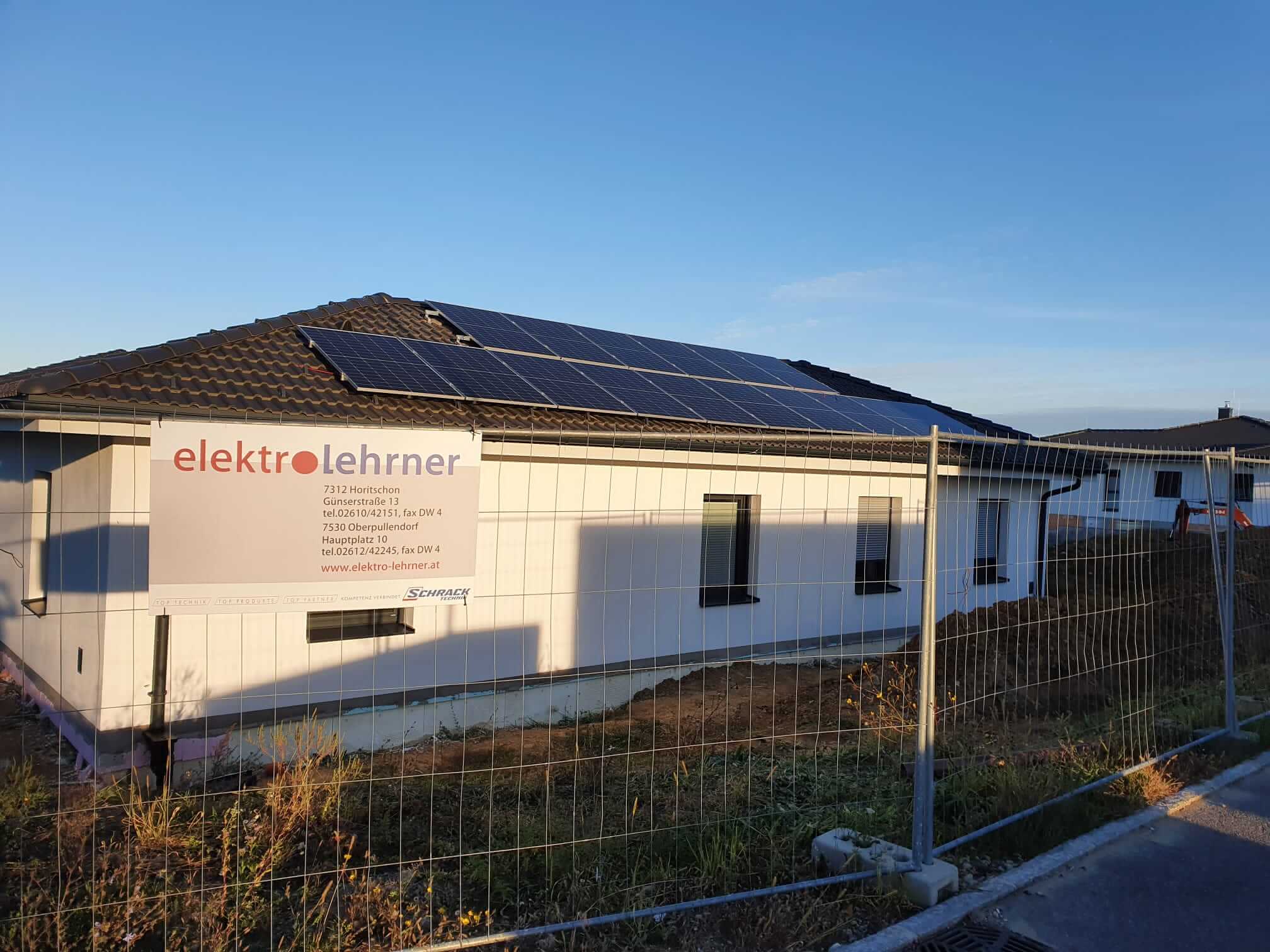 Photovoltaikanlage auf einem braunen Dach eines weißen Hauses