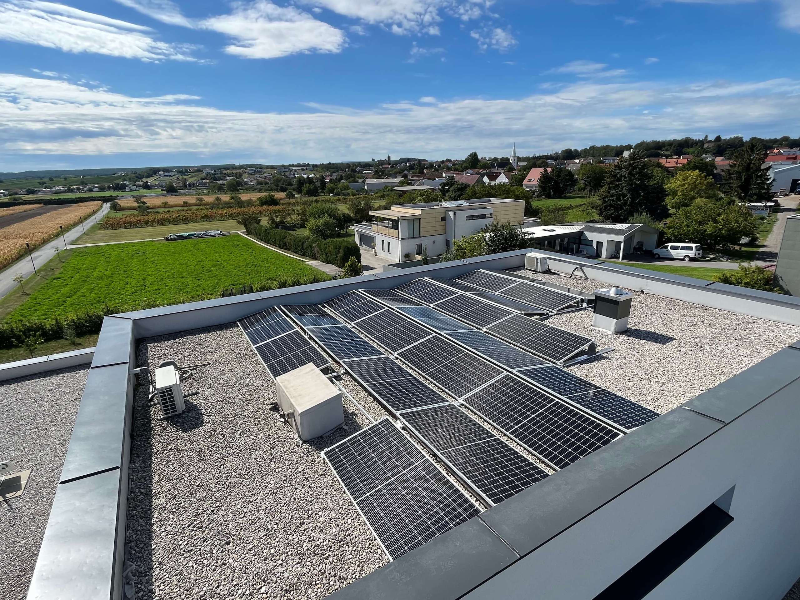 Photovoltaikanlage auf einem Flachdach mit Ausblick auf den Ort